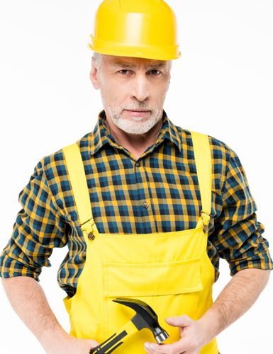 mature-workman-in-hard-hat-holding-hammer-and-look-H38DWSU